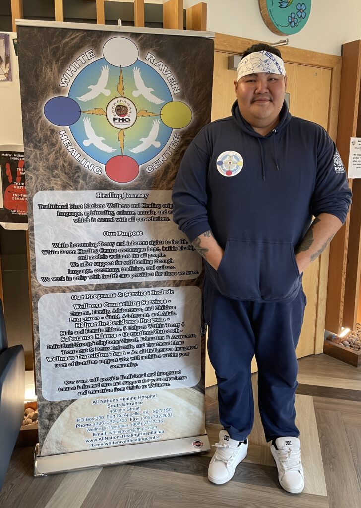 Mitchell Soo-Oyewaste standing beside a WRHC banner. Photo by Emma LeClair